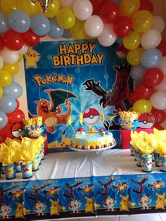 a birthday party with mickey mouse decorations and balloons on the table in front of it