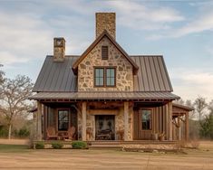 a stone house with a metal roof and porch