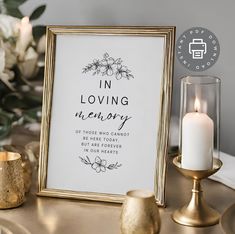 a white and gold framed print with the words in loving memory next to some candles