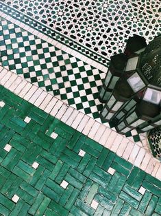 a green and white tiled floor next to a lamp