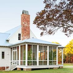 a white house sitting on top of a lush green field