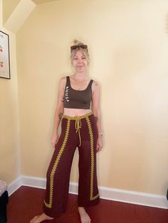 a woman standing in front of a wall with her hands on her hips and smiling at the camera