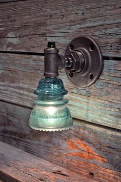 an old fashioned light fixture on the side of a wooden wall