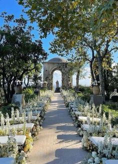 an outdoor ceremony set up with white flowers and greenery