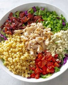 a white bowl filled with pasta salad and meat