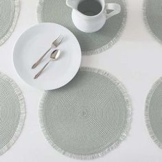 the place setting is ready to be served with silverware and coffee cup on white plates