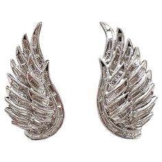 two silver metal angel wings on a white background