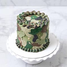 a camouflage cake is sitting on a white plate