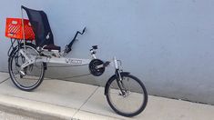 a bicycle parked next to a blue wall with a red basket on the front wheel