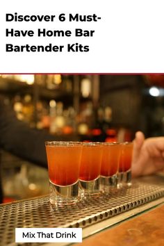 a bar with three glasses filled with drinks on top of it and the words, discovery 6 must have home bar bartender kits