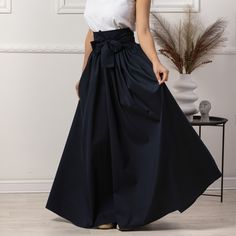 Elevate your style with our Long Flared Skirt, a chic and versatile addition to your wardrobe. Crafted from soft and breathable cotton, this high-waisted maxi skirt gracefully cascades to the floor, featuring a flattering flare and convenient side pockets. The charming bow detail at the waist adds a touch of sophistication, and with a variety of color options, you can effortlessly tailor your look to suit any occasion.  Enjoy the effortless fit and the feminine sense when wearing our creations! Elegant Cotton Skirt, Elegant Cotton Maxi Skirt, Elegant Cotton Maxi Skirt For Spring, Elegant Cotton Lined Skirt, Cotton Voluminous Maxi Skirt For Work, Elegant Cotton Maxi Skirt For Summer, Elegant Cotton Pleated Skirt, Elegant Long Cotton Skirt, Elegant Cotton Bottoms With Voluminous Skirt