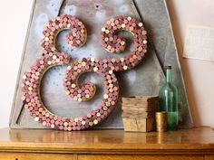 a wooden sign with pink and yellow dots on it sitting on top of a dresser