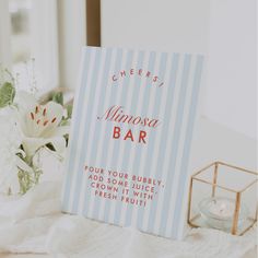 a menu sitting on top of a table next to a vase filled with white flowers