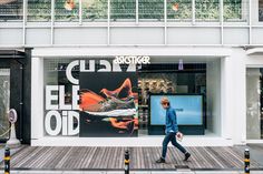 a man walking past a store front on a city street