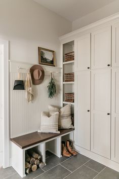 an image of a room with white walls and shelves on the wall, including a bench