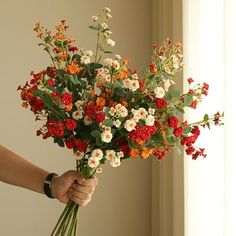 a person holding a bouquet of flowers in their hand