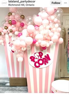 pink and white popcorn buckets filled with balloons