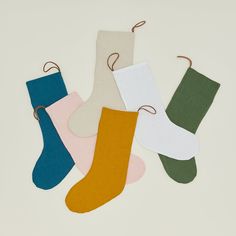 five pairs of socks hanging from strings on a white surface, with one sock in the middle