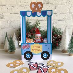 a christmas card with a train and cookies on the table next to it is an elf's hat