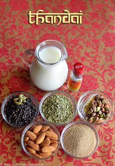 various spices and nuts are arranged in bowls on a table next to a jug of milk