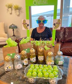 a woman sitting in front of a table filled with lots of green food and decorations