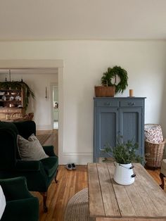 a living room filled with furniture next to a wooden table and wall mounted potted plants