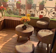 the balcony is decorated with potted plants and wicker furniture, along with flower arrangements