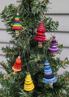 colorful ornaments are hanging from the top of a christmas tree