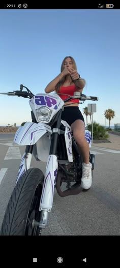 a woman sitting on top of a white motorcycle