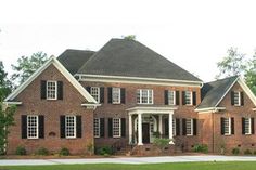 a large brick house with black shutters and white trim