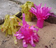 three pink and yellow flowers sitting on the ground