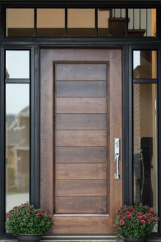 a wooden door with two planters on the side