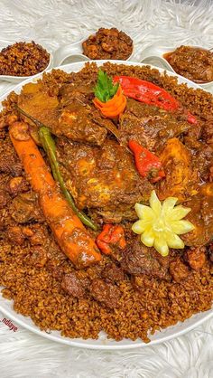 a large plate filled with meat and vegetables on top of rice covered in sauces