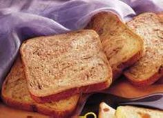 three pieces of bread sitting on top of a cutting board next to nuts and honey