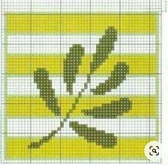 a cross stitch pattern with green leaves on yellow and white striped background, in the shape of a leaf