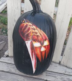 a painted pumpkin sitting on top of a wooden bench