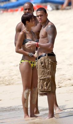 two men and a woman standing on the beach