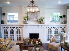 a living room filled with furniture and a fire place under a chandelier over a fireplace