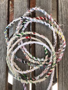 several pieces of rope hanging from a wooden fence