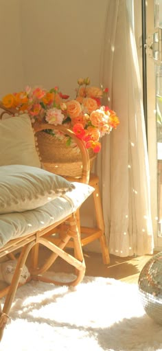 the sun shines brightly in front of a window with flowers and a chair next to it