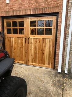 a motorcycle parked in front of a wooden garage door with glass panels on the doors