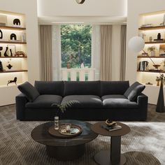 a living room filled with black furniture and lots of bookshelves on the wall