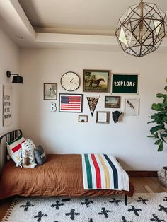 a bedroom with pictures on the wall and a small bed in front of it,