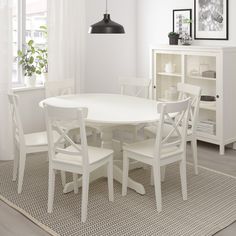 a white table and chairs in a room with a rug on the floor next to it