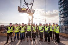 a group of men in safety vests standing next to each other