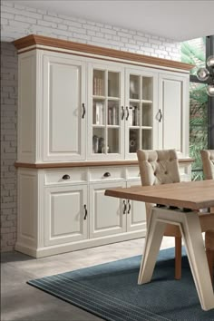 a dining room table with chairs and cupboards