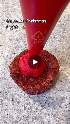 a cupcake with a red frosting on top is being blown into the air