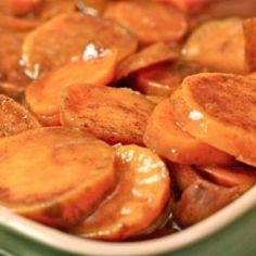 closeup of sliced carrots with sauce in a white bowl on a table top