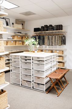 an organized closet with white drawers and baskets