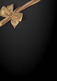 a gold ribbon with a bow on it is hanging from the side of a black wall